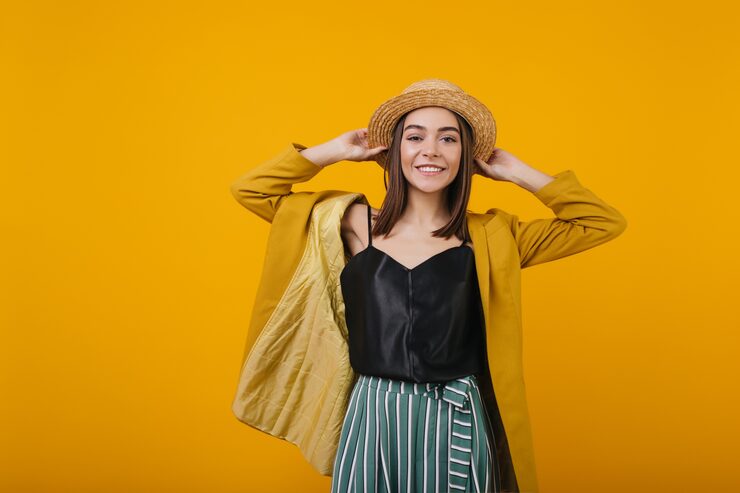 Smiling woman wearing a straw hat and black tank top